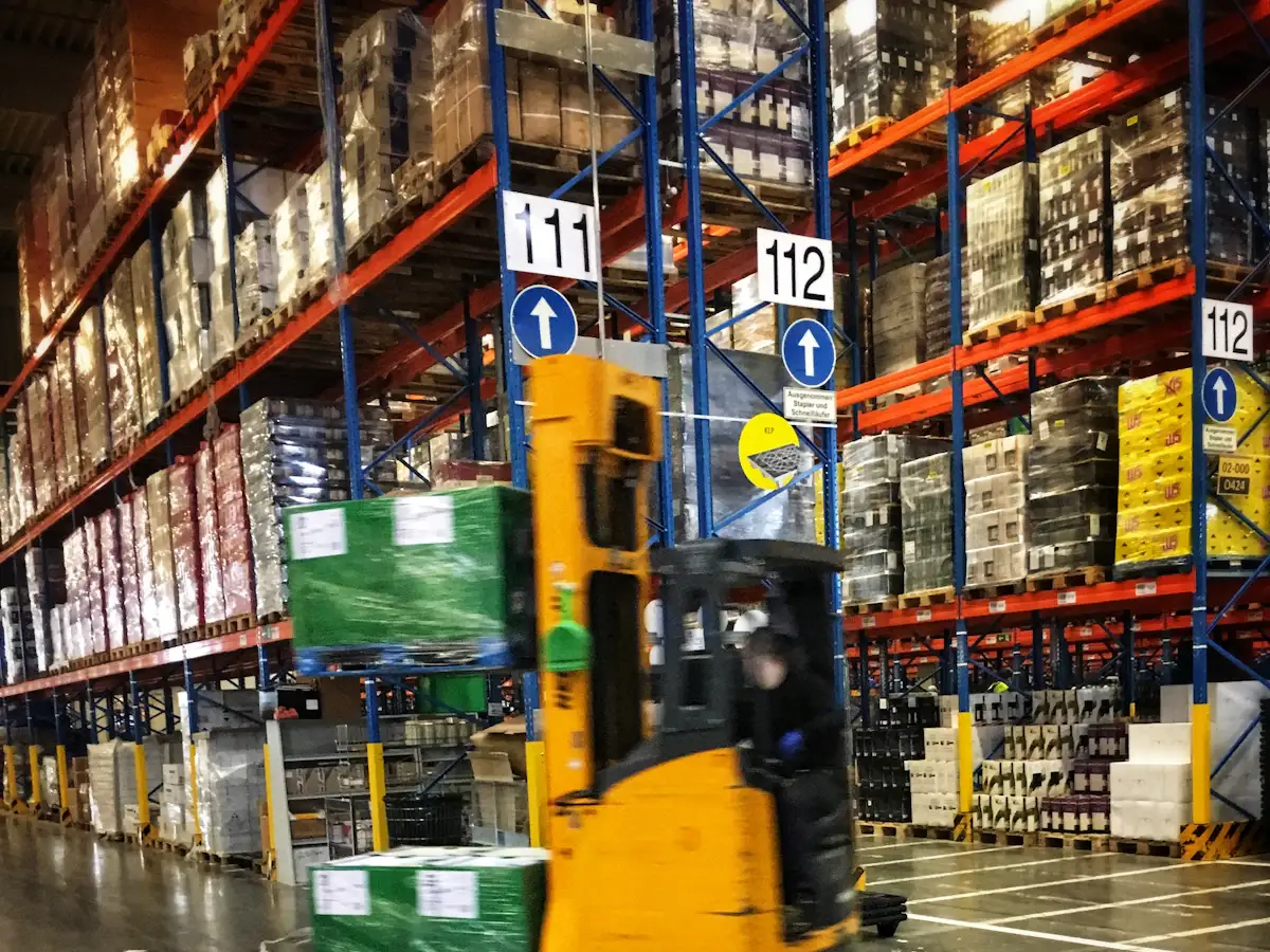 Forklift moving through a warehouse of pallet racking.